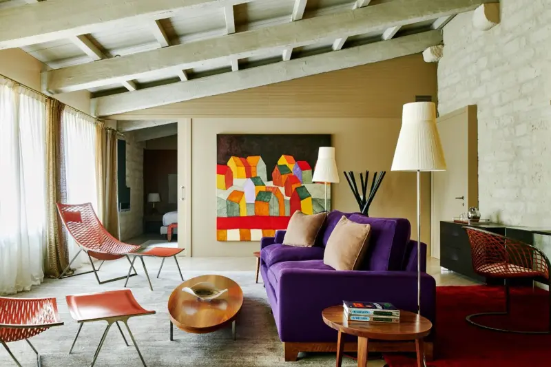 Salón de la Mercer Suite, con vigas de madera y sofá morado